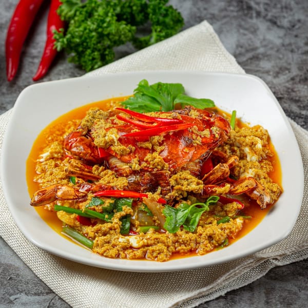 Thai Time's stir-fried crab in yellow curry sauce, garnished with red chilies and green herbs.